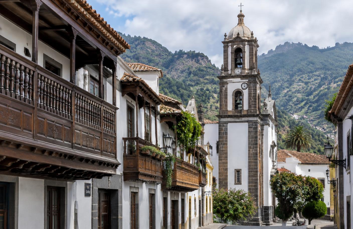 Calle con balcones de madera canarios y la Basílica del Pino en Teror
